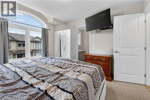 Arched window with multiple panes, light-colored walls, and carpet flooring - 19 Picardy Drive Unit# 13, Hamilton, ON - Indoor Photo Showing Bedroom