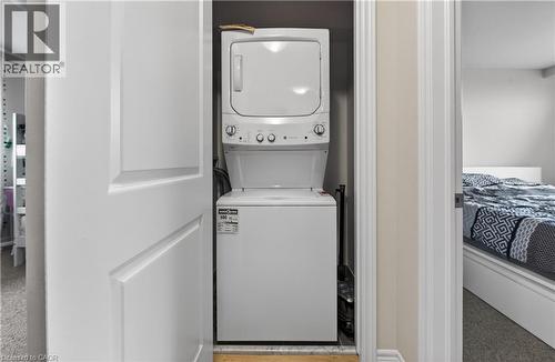White stackable washer and dryer unit within a dedicated closet - 19 Picardy Drive Unit# 13, Hamilton, ON - Indoor Photo Showing Laundry Room