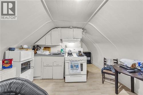 Compact kitchen with white cabinetry, a single basin sink, and a white gas range - 1367 Cannon Street E, Hamilton, ON - Indoor