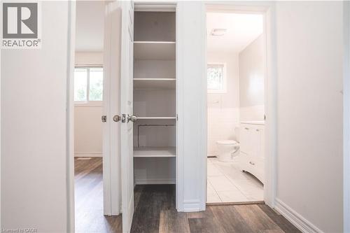 Hallway featuring abundant built-in storage with multiple shelves, wood-finish flooring, and bright natural lighting from nearby windows - 695 Glen Forrest Boulevard Unit# Upper, Waterloo, ON - Indoor Photo Showing Other Room