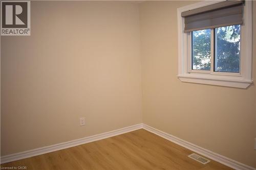Neutral tone wall finish, wood-finish flooring, white window trim, and a sliding window - 655 Albert Street Unit# A, Waterloo, ON - Indoor Photo Showing Other Room
