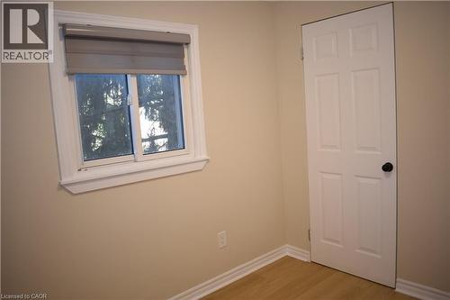Light-toned walls, wood-finish flooring, white trim, and a paneled door - 655 Albert Street Unit# A, Waterloo, ON - Indoor Photo Showing Other Room