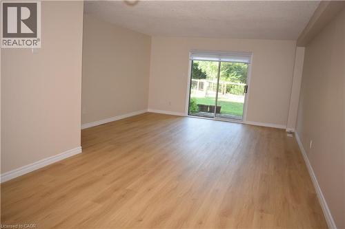 Wood-finish flooring, neutral wall tones, and sliding glass door - 655 Albert Street Unit# A, Waterloo, ON - Indoor Photo Showing Other Room