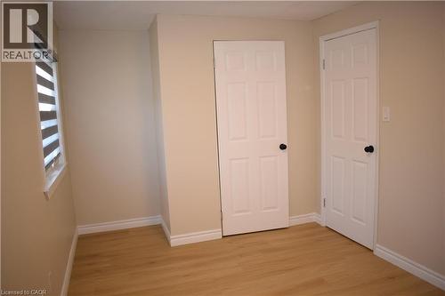 Light wood-finish flooring with neutral wall paint - 655 Albert Street Unit# A, Waterloo, ON - Indoor Photo Showing Other Room