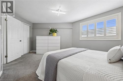 Window with white plantation shutters, gray wall paint, and gray carpet - 60 Elmsdale Drive Unit# 25, Kitchener, ON - Indoor Photo Showing Bedroom