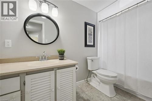 Vanity with a single basin sink, chrome faucet, and louvered cabinet doors - 60 Elmsdale Drive Unit# 25, Kitchener, ON - Indoor Photo Showing Bathroom