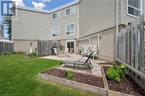 Private backyard featuring a paved patio area, an adjacent wooden deck, and raised garden beds - 60 Elmsdale Drive Unit# 25, Kitchener, ON - Outdoor With Deck Patio Veranda