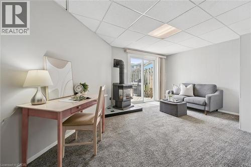 Recessed ceiling light, wall-to-wall carpeting, wood-burning stove with hearth, and sliding glass door - 60 Elmsdale Drive Unit# 25, Kitchener, ON - Indoor