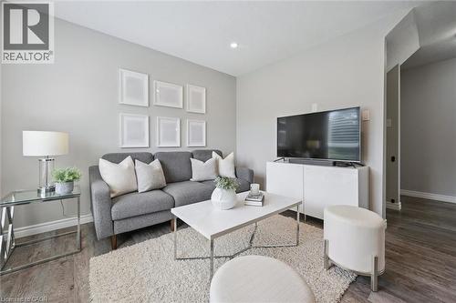 Recessed ceiling lighting, light gray wall finishes, and wood-finish flooring - 60 Elmsdale Drive Unit# 25, Kitchener, ON - Indoor Photo Showing Living Room