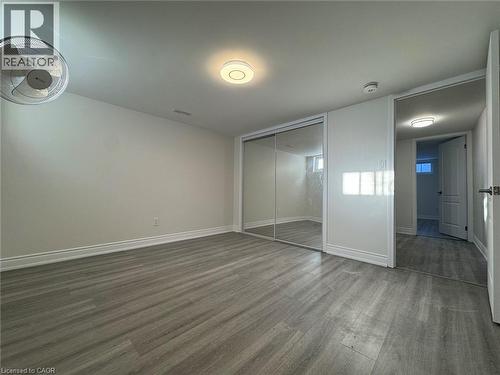 Wood-finish flooring, mirrored closet doors, and recessed lighting - 15 Pinecrest Drive Unit# Lower, Kitchener, ON - Indoor Photo Showing Other Room