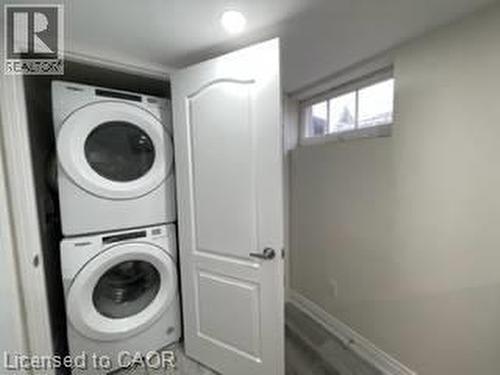 Stacked washer and dryer units, overhead recessed lighting, and a white interior door with dark hardware - 15 Pinecrest Drive Unit# Lower, Kitchener, ON - Indoor Photo Showing Laundry Room