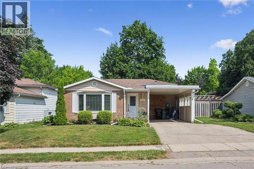 Charming brick ranch home featuring a welcoming front facade with covered entry portico, two-car attached garage, and mature landscaping throughout the grounds - 659 Glen Forrest Boulevard, Waterloo, ON - Outdoor With Facade