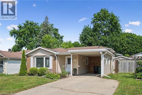 Single-story residence featuring a carport, a paved driveway, and mature landscaping - 659 Glen Forrest Boulevard, Waterloo, ON - Outdoor With Facade