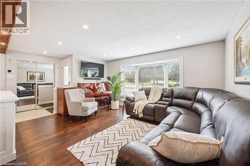 Spacious living area showcasing hardwood flooring, recessed ceiling lighting, and expansive multi-pane windows framing natural light - 659 Glen Forrest Boulevard, Waterloo, ON - Indoor Photo Showing Living Room