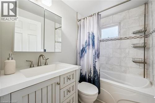 Spa-inspired bathroom featuring a vanity with multiple drawers and brushed nickel hardware, white subway tile surround, polished countertop, and dual wall-mounted shelving - 659 Glen Forrest Boulevard, Waterloo, ON - Indoor Photo Showing Bathroom