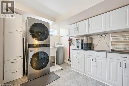 Integrated laundry appliances with white cabinetry, a utility sink, and ample counter space - 659 Glen Forrest Boulevard, Waterloo, ON - Indoor Photo Showing Laundry Room