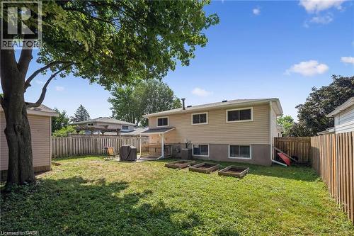Expansive backyard featuring a mature shade tree, manicured lawn, and wooden deck with steps leading to the two-story residence - 659 Glen Forrest Boulevard, Waterloo, ON - Outdoor