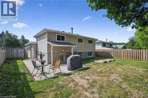 Fenced backyard featuring a concrete patio, covered deck, and exterior lighting - 659 Glen Forrest Boulevard, Waterloo, ON - Outdoor With Deck Patio Veranda