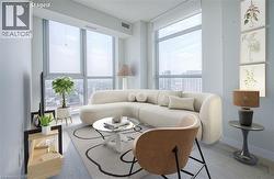 Floor-to-ceiling windows, light wood-finish flooring, and light-toned walls - 