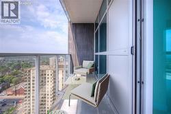 Balcony featuring a glass railing, concrete flooring, and sliding glass panel doors - 