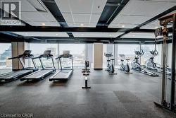 Fitness area featuring floor-to-ceiling windows, rubber flooring, and a drop ceiling with recessed lighting - 