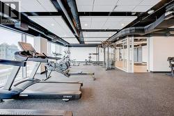 Fitness facility with floor-to-ceiling windows, exposed ductwork, recessed lighting, and resilient flooring - 