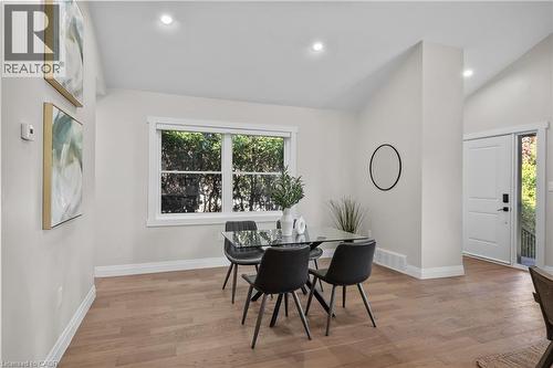 Bright, open dining area showcasing wood-finish flooring, large multi-pane windows with natural light, recessed ceiling lighting, and clean white walls with crisp architectural detailing - 1041 Shepherd'S Drive, Burlington, ON - Indoor