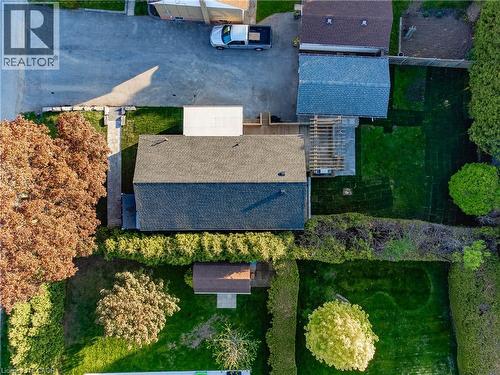 Expansive property featuring a paved driveway, a shingled roof, a wooden deck, a pergola, and mature trees - 1041 Shepherd'S Drive, Burlington, ON - Outdoor