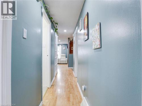 Modern hallway featuring soft blue-painted walls, wood-finish flooring, recessed ceiling lighting, and white trim throughout - 128 Macatee Place, Cambridge, ON - Indoor Photo Showing Other Room