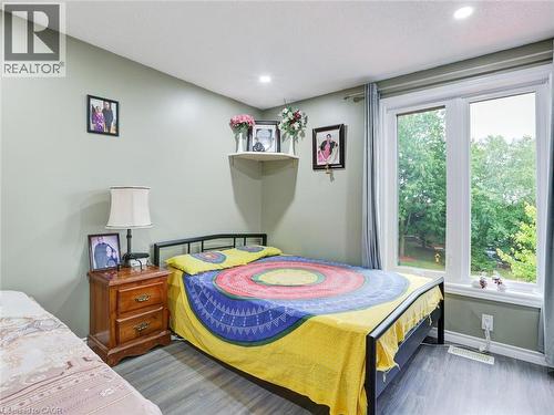 Recessed ceiling lighting, durable wood-finish flooring, and a large window with white trim - 128 Macatee Place, Cambridge, ON - Indoor Photo Showing Bedroom
