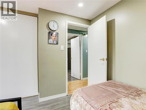 Bright bedroom offering wood-finish flooring, recessed ceiling lighting, and direct access to an ensuite bathroom - 128 Macatee Place, Cambridge, ON - Indoor Photo Showing Bedroom