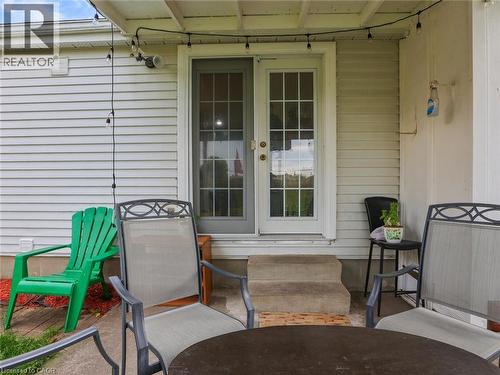 Covered porch with dual French doors featuring multiple panes, complemented by concrete flooring and overhead track lighting - 128 Macatee Place, Cambridge, ON - Outdoor With Exterior
