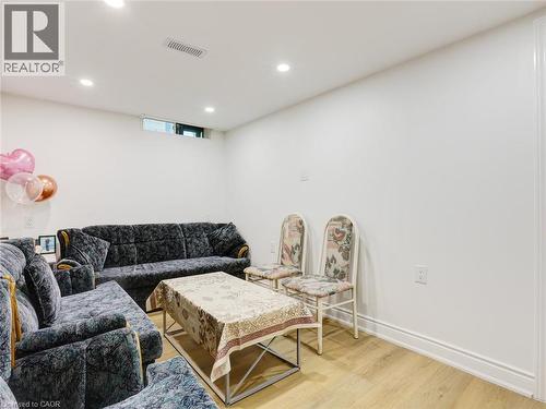 Finished basement recreation room featuring recessed ceiling lighting, wood-finish flooring, and neutral wall finishes - 128 Macatee Place, Cambridge, ON - Indoor Photo Showing Other Room