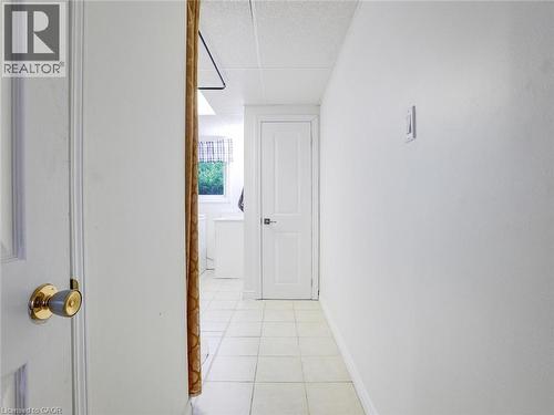 Hallway with white painted walls, square tile flooring, and white interior doors - 128 Macatee Place, Cambridge, ON - Indoor Photo Showing Other Room
