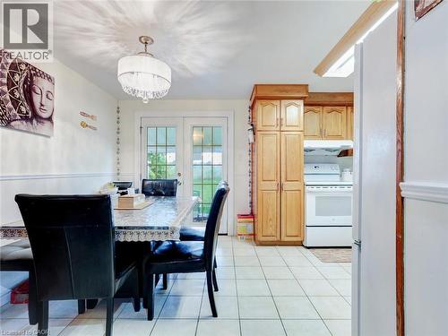 Kitchen with wood-finish cabinetry, white appliances, and tiled flooring - 128 Macatee Place, Cambridge, ON - Indoor Photo Showing Dining Room