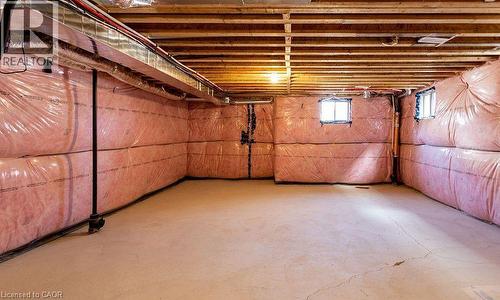 Unfinished basement with exposed ceiling joists, concrete flooring, two windows, and insulated walls - 16 Monteith Drive, Brantford, ON - Indoor Photo Showing Basement