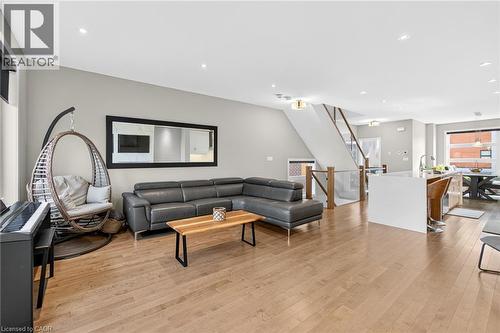 Hardwood flooring throughout, recessed lighting, white walls, and a staircase with wood and glass railings - 60 Arkell Road Unit# 57, Guelph, ON - Indoor Photo Showing Living Room