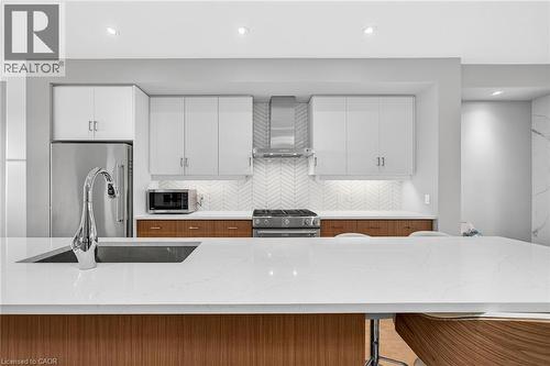 Expansive quartz countertop with an undermount sink and chrome faucet - 60 Arkell Road Unit# 57, Guelph, ON - Indoor Photo Showing Kitchen With Upgraded Kitchen