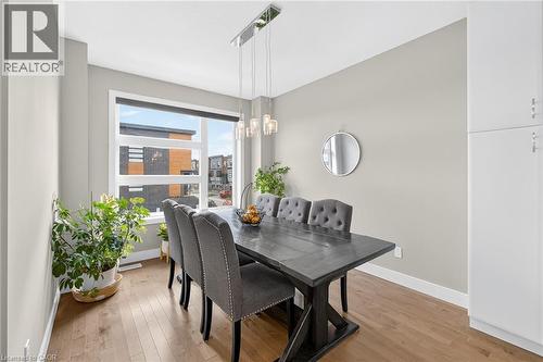 Large window with a roller shade, wood-finish flooring, and light gray walls - 60 Arkell Road Unit# 57, Guelph, ON - Indoor Photo Showing Dining Room