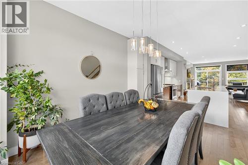 Open-concept dining area featuring wood-finish flooring, a contemporary pendant light fixture, and recessed lighting - 60 Arkell Road Unit# 57, Guelph, ON - Indoor Photo Showing Dining Room