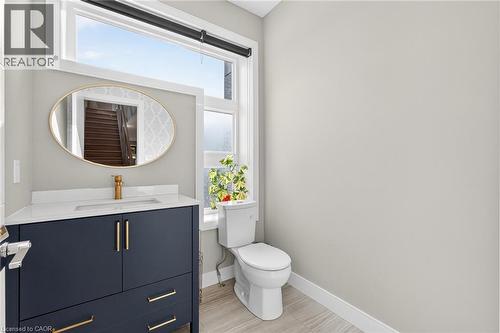 Modern vanity with a dark finish, white countertop, and gold-finish fixtures - 60 Arkell Road Unit# 57, Guelph, ON - Indoor Photo Showing Bathroom