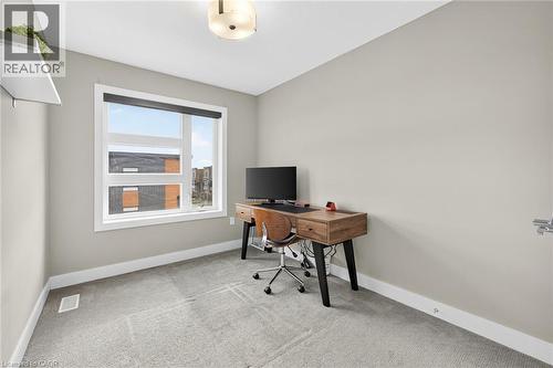 Carpeted flooring, contemporary light fixture, a large window with a roller shade, and a built-in wall shelf - 60 Arkell Road Unit# 57, Guelph, ON - Indoor Photo Showing Office