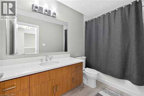 Wood-finish vanity with ample storage, a white countertop, and an undermount sink - 60 Arkell Road Unit# 57, Guelph, ON - Indoor Photo Showing Bathroom