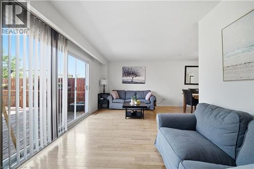 Expansive living area with light wood-finish flooring, white walls, and a large sliding glass door - 230 Sunset Boulevard, Cambridge, ON - Indoor Photo Showing Living Room