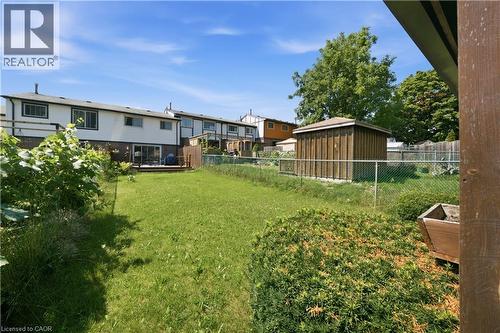 Expansive grassy yard with a storage shed, chain-link fencing, and a rear deck with sliding glass doors - 230 Sunset Boulevard, Cambridge, ON - Outdoor