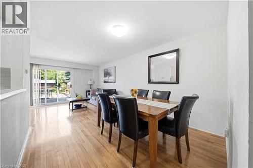 Hardwood flooring throughout, sliding glass door, white walls, flush mount ceiling light, and a built-in half-wall with tile accent - 230 Sunset Boulevard, Cambridge, ON - Indoor Photo Showing Dining Room