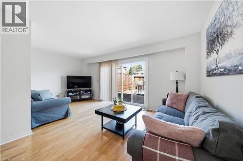 Hardwood flooring throughout, white walls, and a sliding glass door providing direct access to an outdoor deck - 230 Sunset Boulevard, Cambridge, ON - Indoor Photo Showing Living Room