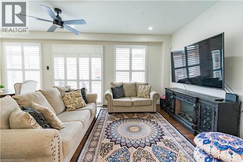 Recessed lighting, wood-finish flooring, white plantation shutters, and a ceiling fan with integrated lighting - 122 Iron Gate Street, Kitchener, ON - Indoor Photo Showing Living Room With Fireplace
