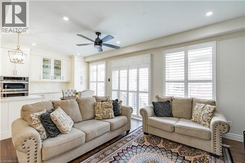 Recessed lighting, dark wood-finish flooring, white window shutters, built-in cabinetry, and a ceiling fan - 122 Iron Gate Street, Kitchener, ON - Indoor Photo Showing Living Room