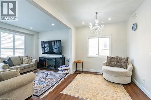 Open-concept living space featuring wood-finish flooring, recessed lighting, and a decorative chandelier - 122 Iron Gate Street, Kitchener, ON - Indoor Photo Showing Living Room